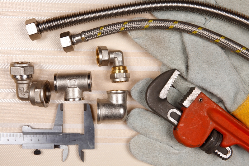 Plumber working on pipes in a West Watford home